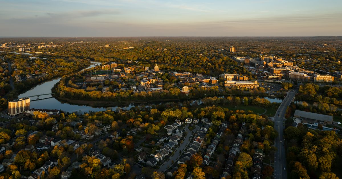 Aerial view of the University of Rochester campus showcasing vibrant fall foliage and iconic buildings.