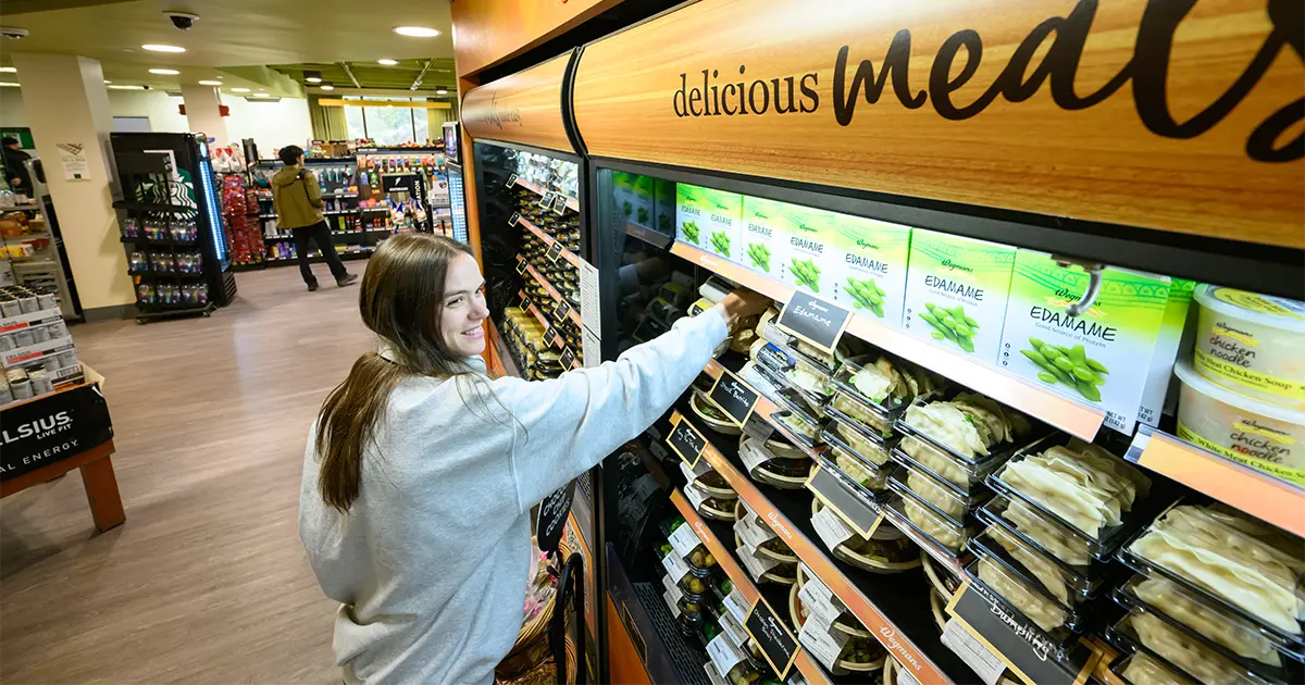 A URochester student grabs Wegmans products off the shelf on campus.